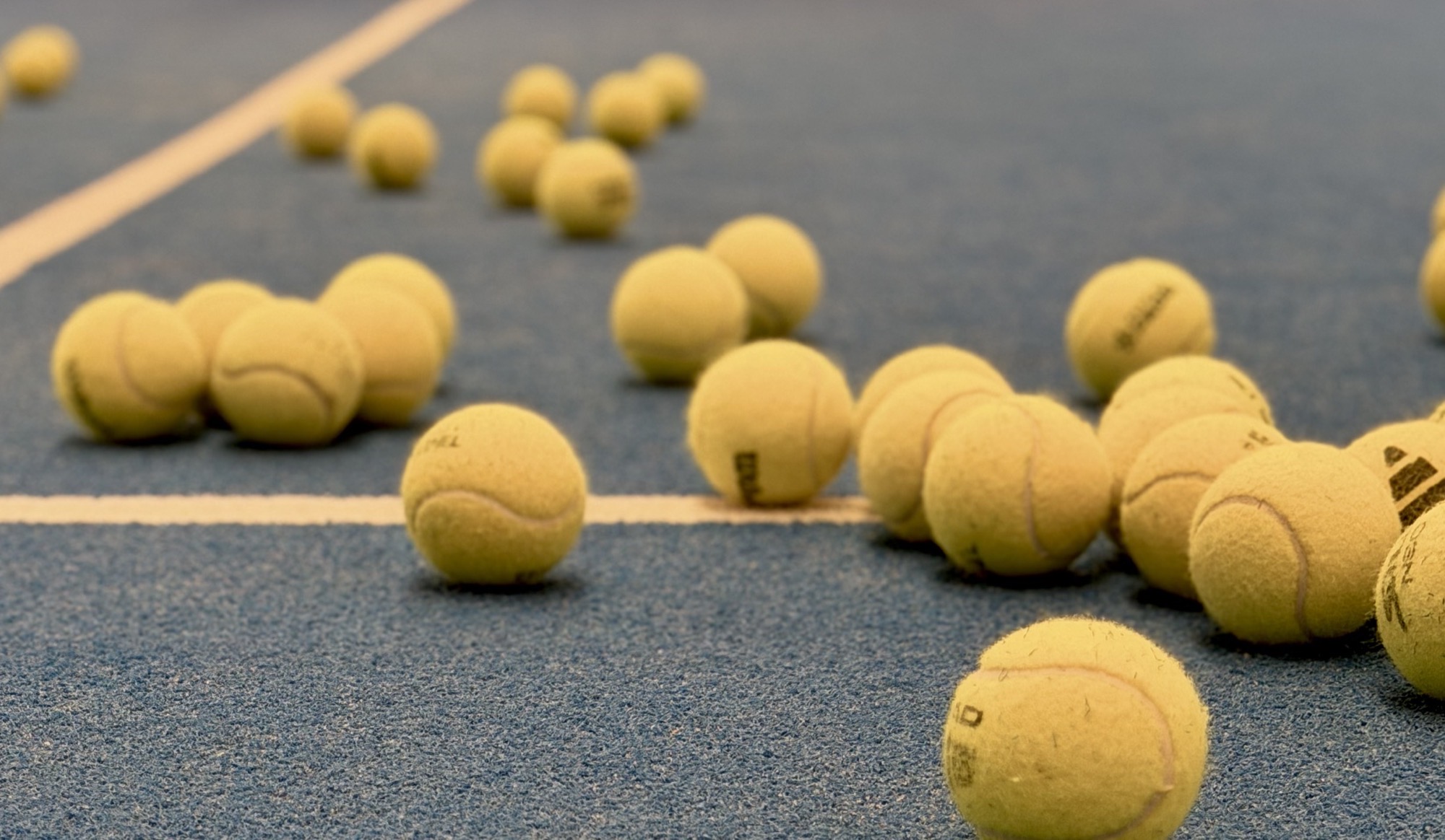 Padel balls scattered across a court